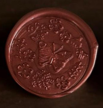 Set of red wax seals on a wooden surface with flowers