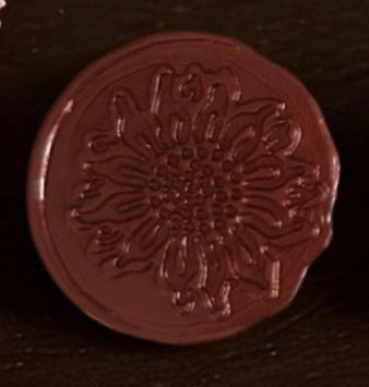 Set of red wax seals on a wooden surface with flowers