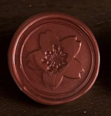 Round red object with a floral design on a dark background