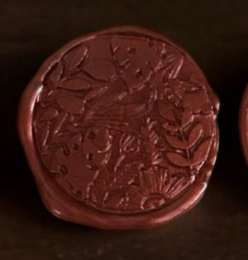 Set of red wax seals on a wooden surface with flowers