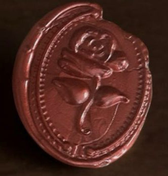 Set of red wax seals on a wooden surface with flowers