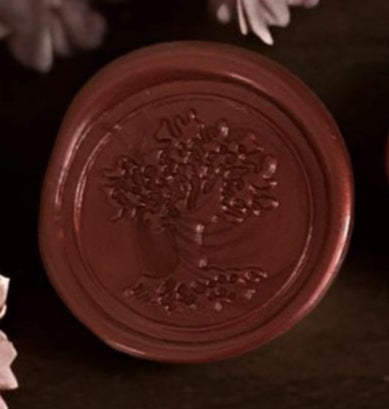 Close-up of a red wax seal with an embossed design on a dark background